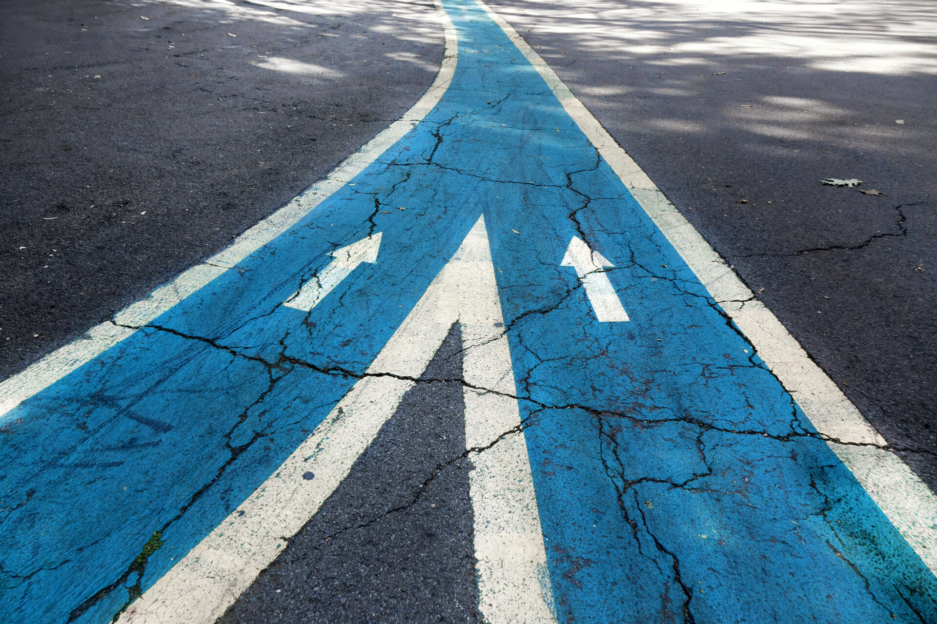 Merging asphalt road with arrow signs